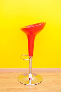 bar chair against a yellow wall in the apartment