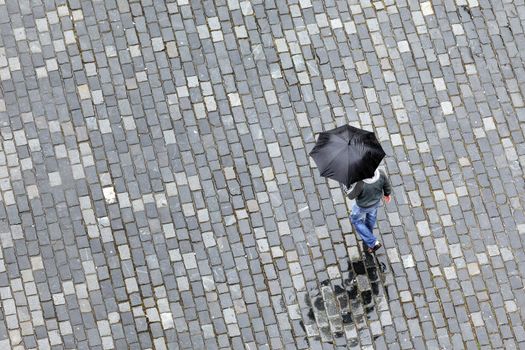 man with umbrella walking under the rain