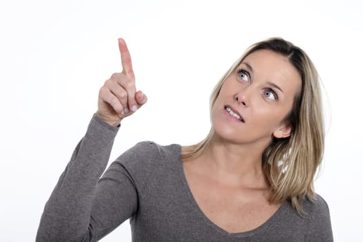 Portrait of beautiful young woman pointing up over white background 