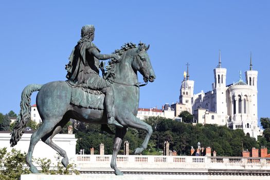 famous statue of Louis XIV and Basilique Fourviere on a background 