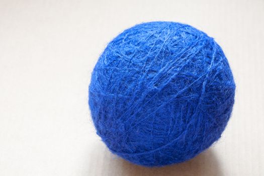 blue wool yarn skein on cardboard background