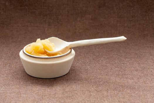 Pot of honey and wooden spoon on a burlap background