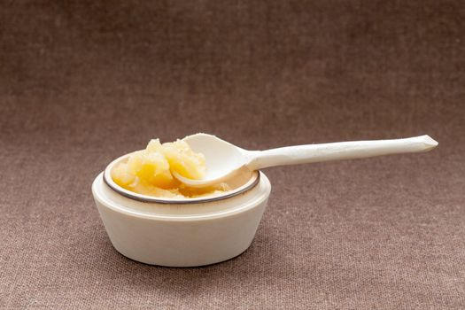 Pot of honey and wooden dipper on a sackcloth background