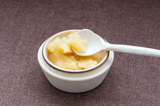 Pot of honey and wooden spoon on a cloth background