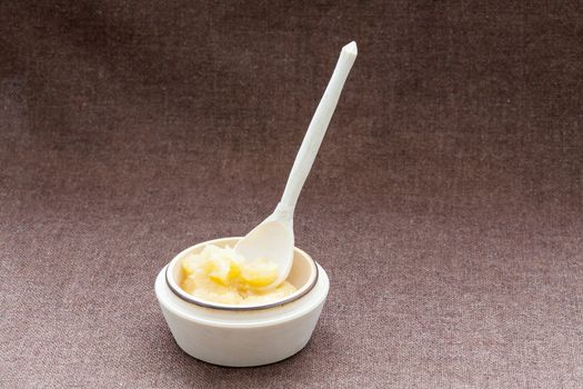 Pot of honey and wooden dipper on a sackcloth background