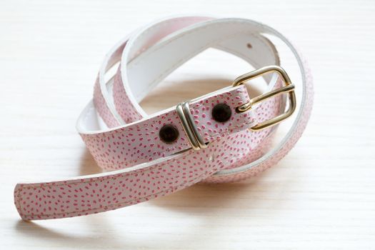 pink women style belt on a light wooden background