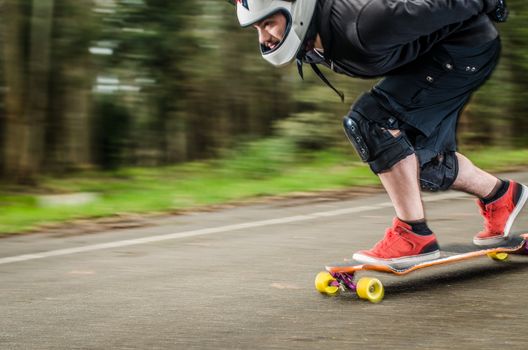 Downhill skateboarder in action on a asphalt road.