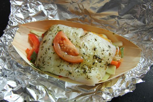 Wolffish fillet with herbs, vegetable and tomato, ready to put in the oven
