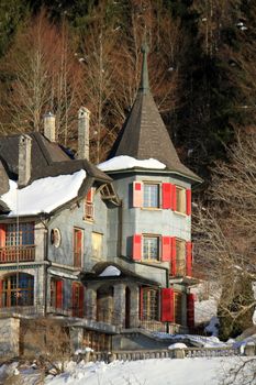 House with towers and red shutters looking like a castle by winter day