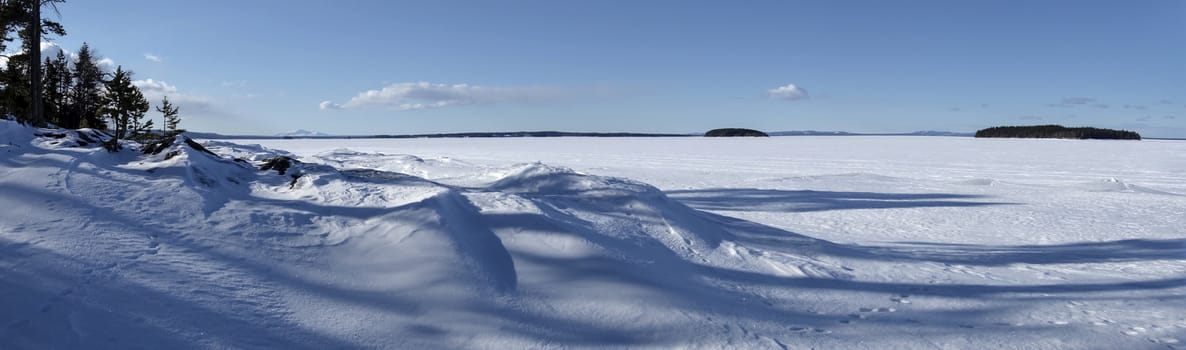 Winter landscape of frozen lake and blue sky