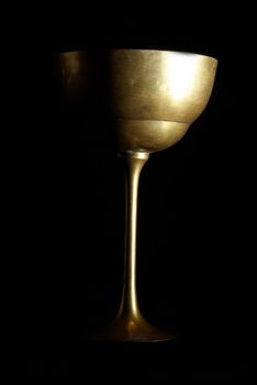 An antique wine cup shot on a low key black background.