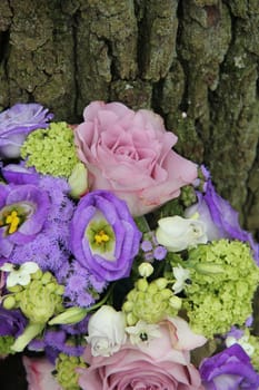 Mixed purple floral arrangement near a tree