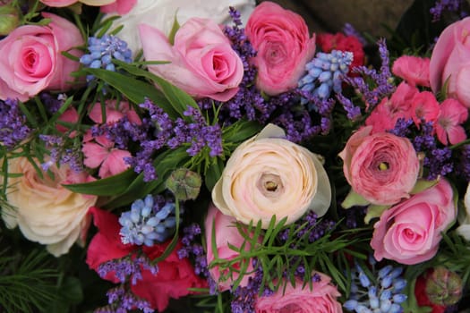 pink roses and ranonkels, blue common hyacints in a spring flower wedding centerpiece