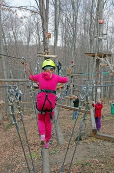 MAGURA, ROMANIA - APRIL 05: Little girl in action in adventure park. Magura Green Park on April 05, 2013 in Magura, Romania