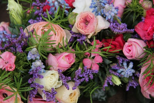 pink roses and ranonkels, blue common hyacints in a spring flower wedding centerpiece