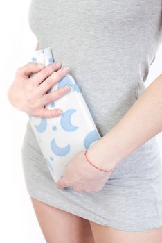 young woman with stomach pain holding hot water bottle