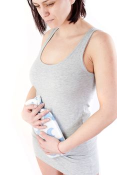 young woman with stomach pain holding hot water bottle