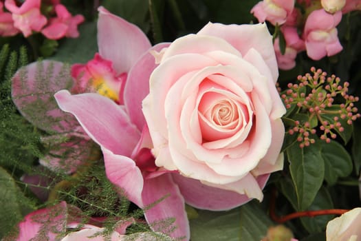 Soft pink rose and orchid in a bridal bouquet