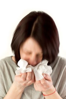 motion blur image of sneezing woman holding tissues, allergy or cold flu concept