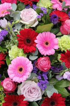 Red and pink gerberas, together with purple roses and other flowers in a wedding arrangement