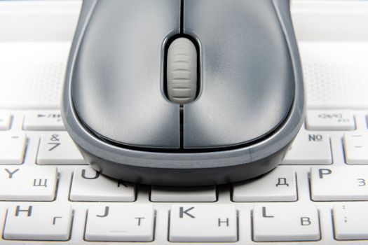 A wireless mouse placed on laptop keyboard