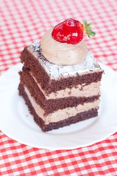 beautiful cake with strawberry on plaid fabric