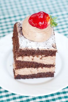 beautiful cake with strawberry on plaid fabric
