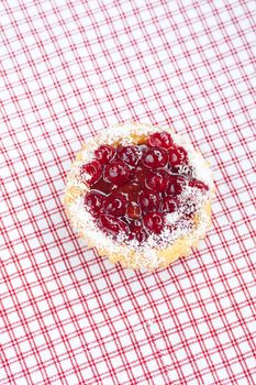 beautiful cake with berries on plaid fabric