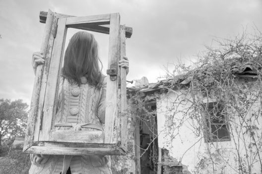 Horror Scene of a scary girl over a spooky abandoned house background