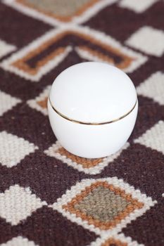 cosmetic containers lying on ethnic mat