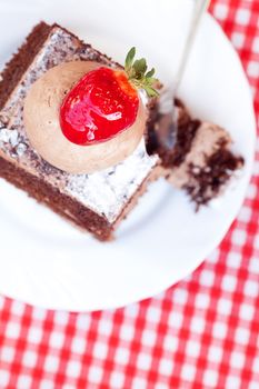 beautiful cake with strawberry on plaid fabric