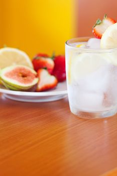 cocktail with ice,lemon, fig and strawberries on a plate