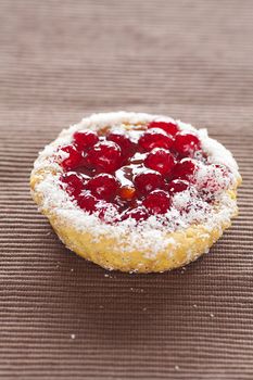 beautiful cake with berries on brown mat