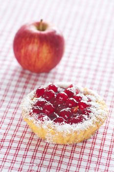 beautiful cake with berries and apple on plaid fabric