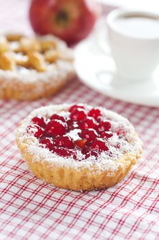 beautiful cake with berries,apple and tea on plaid fabric