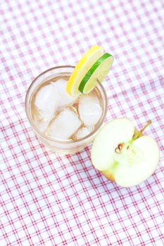 water with lemon and lime,apple in a glass with ice