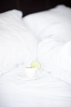 bed with a pillow and a cup of tea 