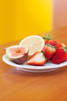 lemon, fig and strawberries on a plate