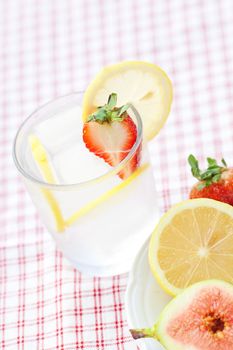 cocktail with ice,lemon, fig and strawberries on a plate