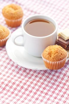 bar of chocolate,tea and muffin on plaid fabric