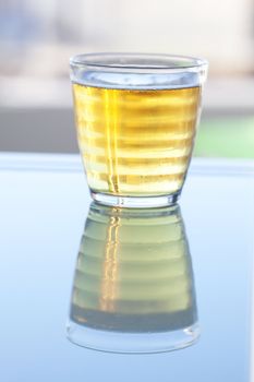 beer in a glass on the reflective surface