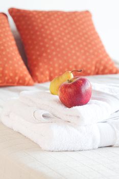 apple and pear lying on the bed