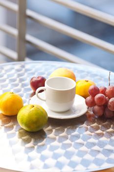 fruits and tea on the table on the balcony