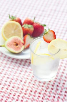 cocktail with ice,lemon, fig and strawberries on a plate