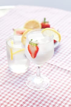 cocktail with ice,lemon, fig and strawberries on a plate