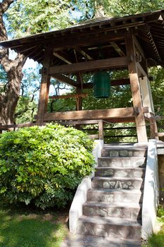 Japanese bell in the background of green trees