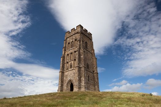 Tourists exploring the ruins of St. Michael's Tower at the top of glastonbury tor in somerest england