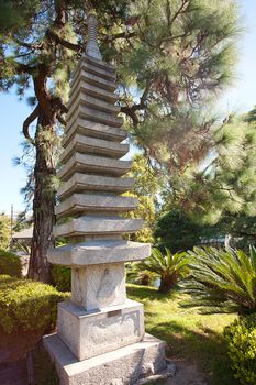 stone pagoda on the background of green trees