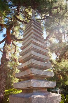 stone pagoda on the background of green trees