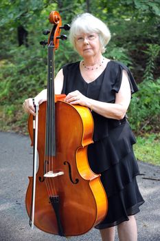 Female cellist standing with her cello.